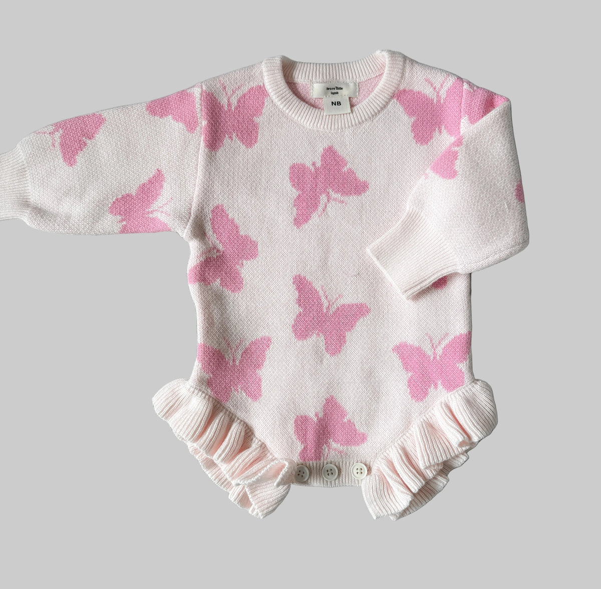 Baby outfit with pink butterfly pattern on a gray background