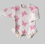 Baby outfit with pink butterfly pattern on a gray background