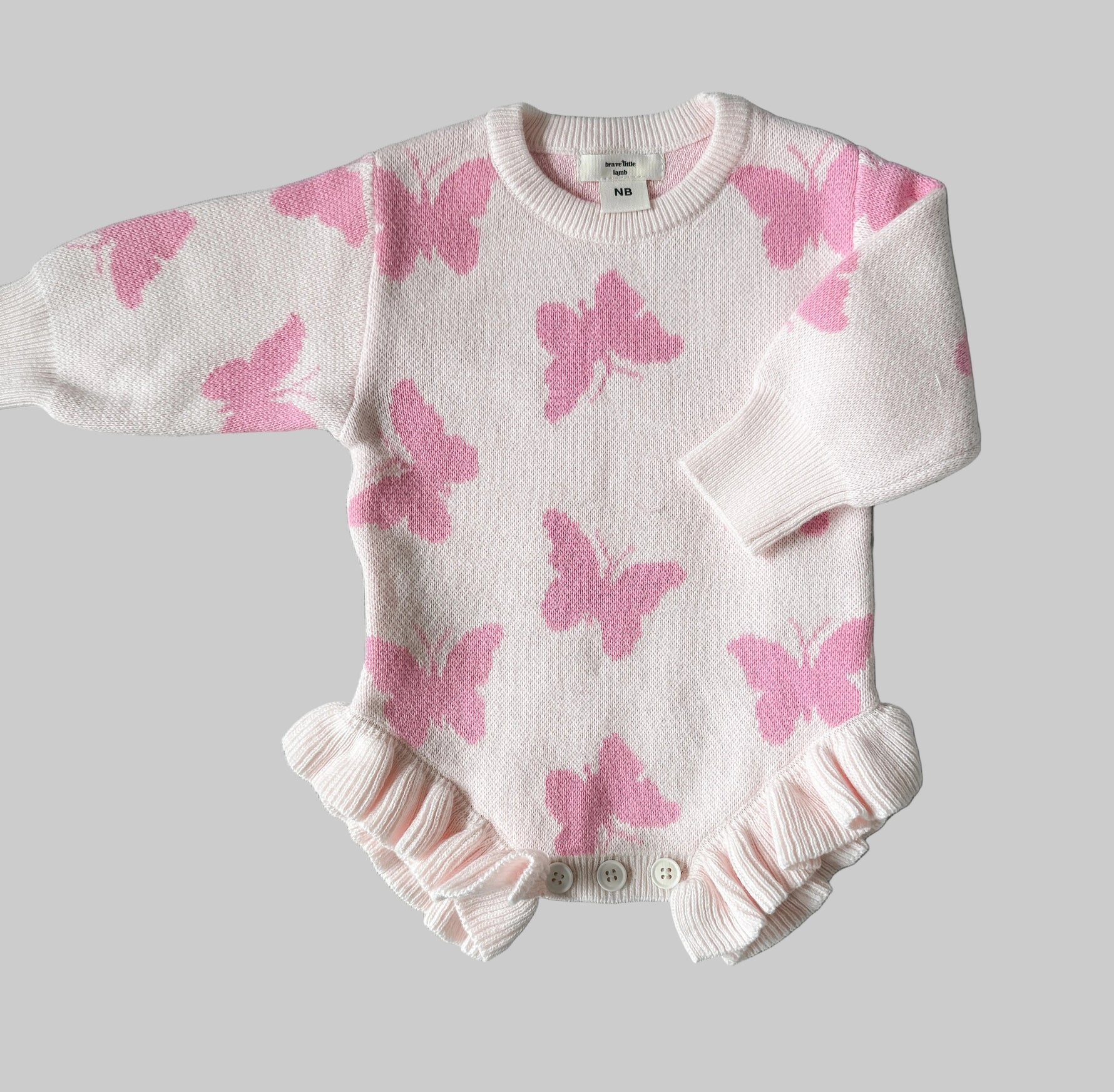 Baby outfit with pink butterfly pattern on a gray background