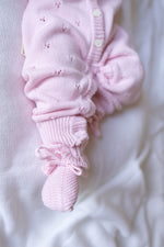 Pink baby outfit withromper and pants on a white background