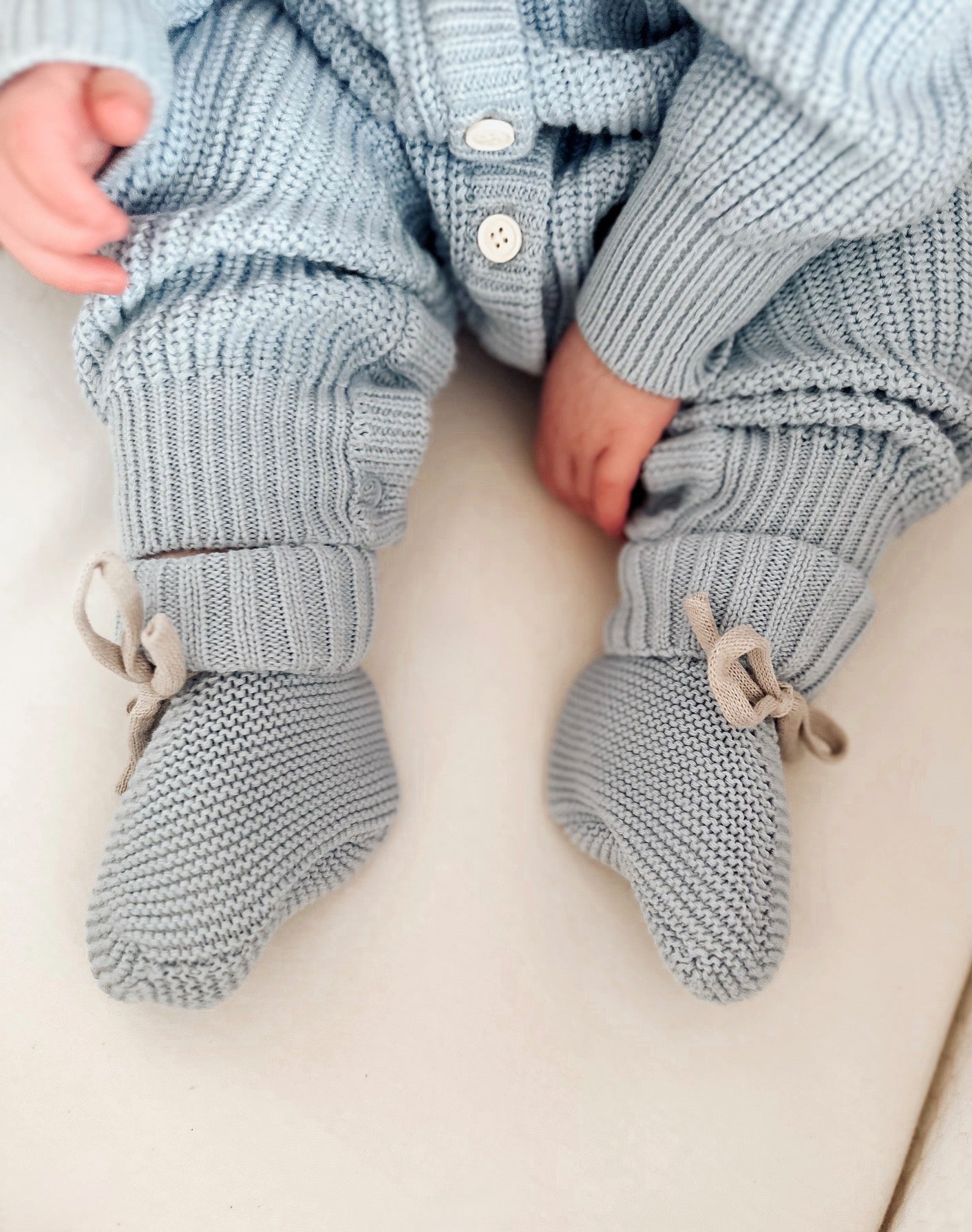 Knitted baby pants and socks on a light background
